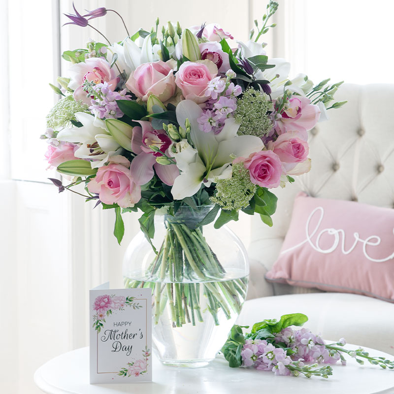 A large bouquet of white lilies, pink roses, pink orchids, white lisianthus, pink stocks and clematis.